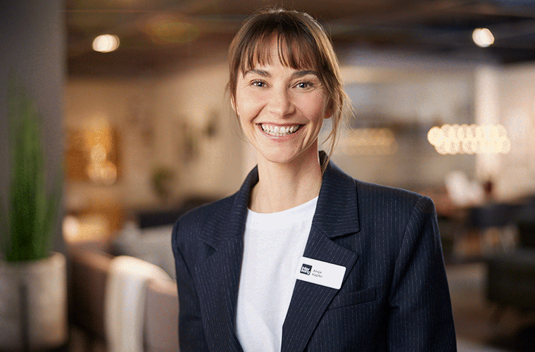 Freundliche Mitarbeiterin lächelt glücklich im Möbelhaus.