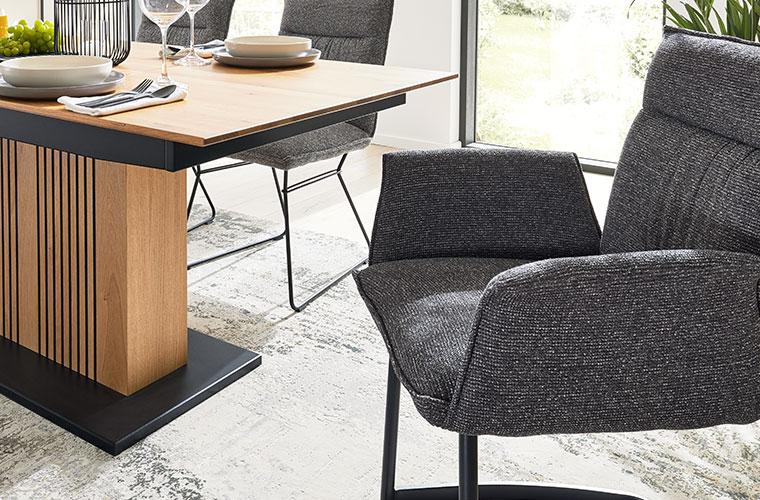 Moderner Essbereich von Interliving mit gepolsterten Stühlen in Dunkelgrau und Esstisch mit Holzfuß.