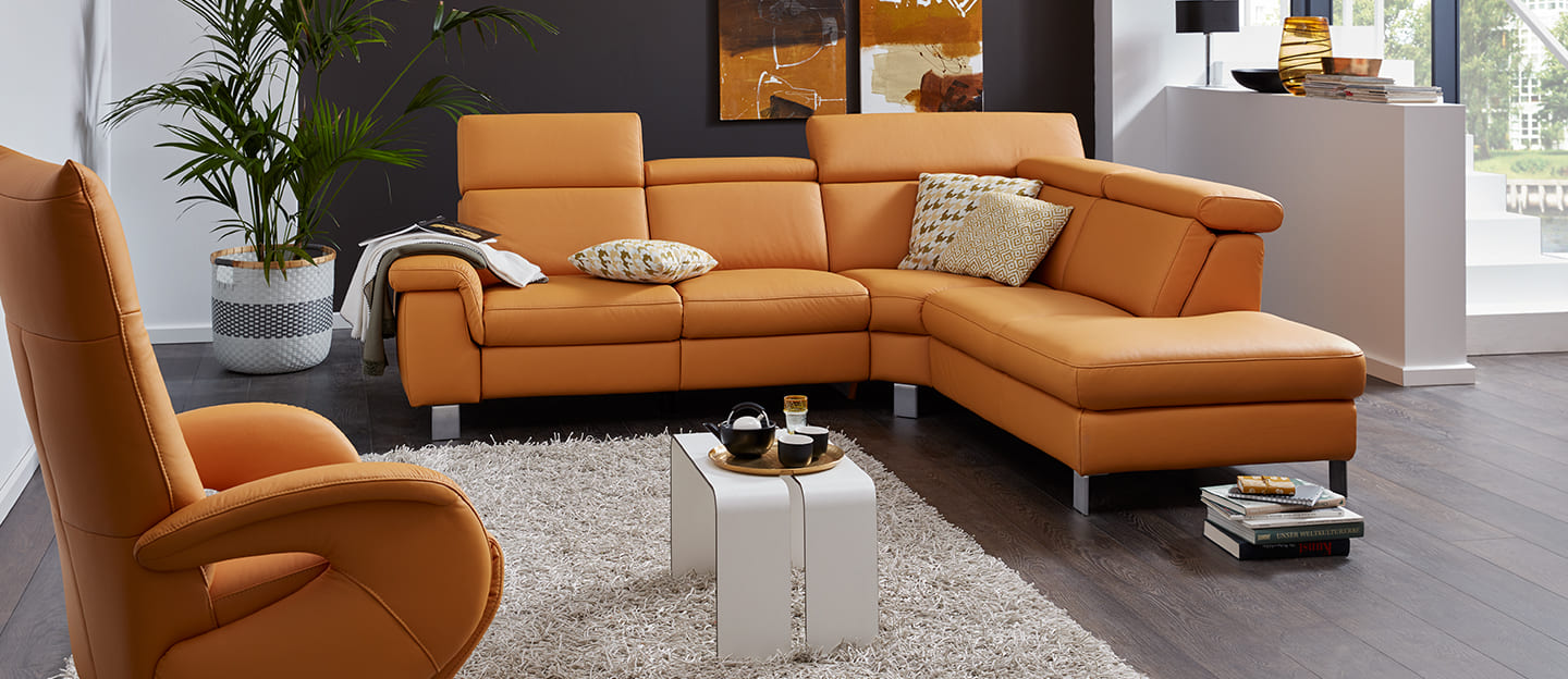 Interliving Eckkombination in dunkelgraue und mit bunten Kissen.