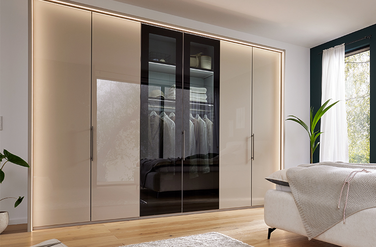 Offener, 3-teiliger Kleiderschrank mit ordentlich hängender Kleidung.