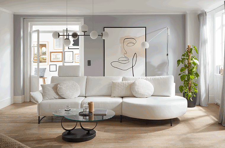 Heller Raum mit weißem Sofa von der Marke Musterring.