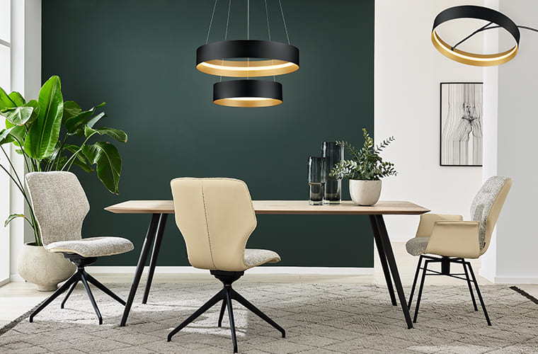 Essbereich mit grauen Polsterstühlen und schwarzem Tisch von Musterring.