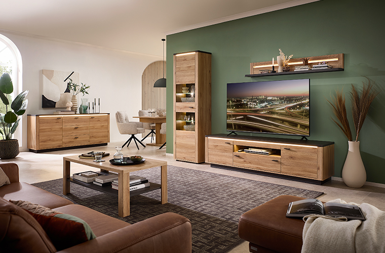 Rosa Zweisitzer-Sofa mit Kissen und Decke in hellem Raum.