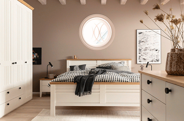Schlafzimmer mit weißen Möbeln und Holzakzenten von SCHÖNER WOHNEN.