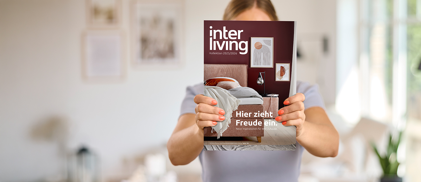 Älterer Herr liest in seinem Sessel ein Prospekt.