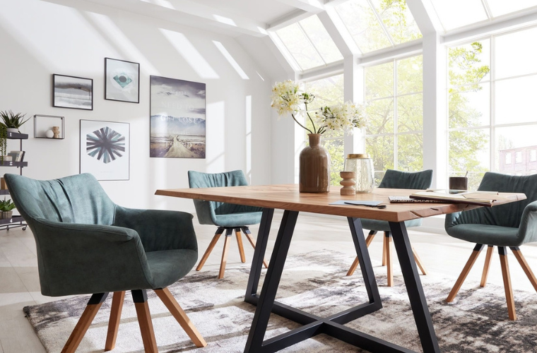 Helles Esszimmer mit Holztisch, grünen Polsterstühlen, großer Fensterfront und moderner Wanddekoration.