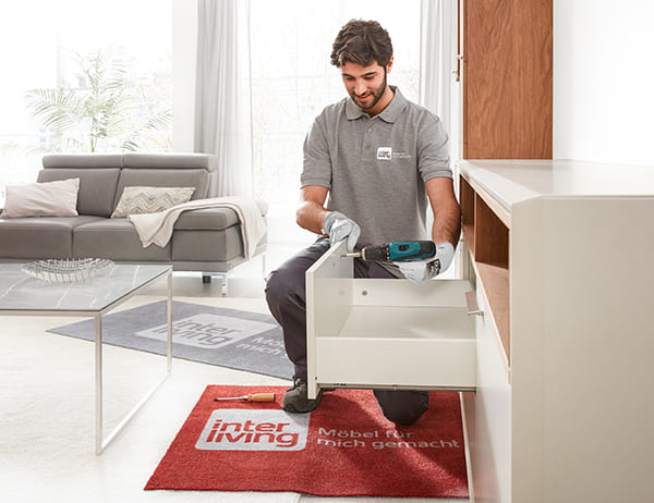 Monteur befestigt eine Schubladenfront in einem hellen Zimmer.