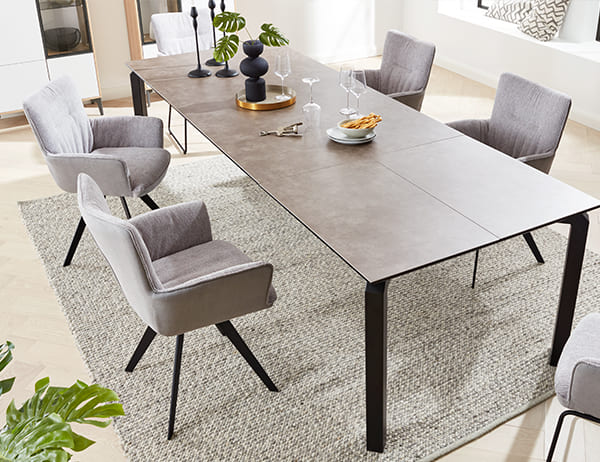 Graue Essgruppe bestehend aus 4 Stühlen und einem langen Tisch.