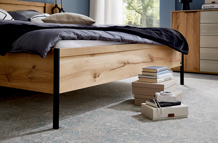 Nahaufnahme von dem Holzrahmen eines Doppelbetts.