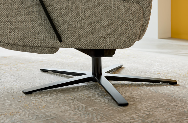 Detailaufnahme des Fußes eines Relaxsessels mit einem schwarzen Drehkreuz-Gestell.