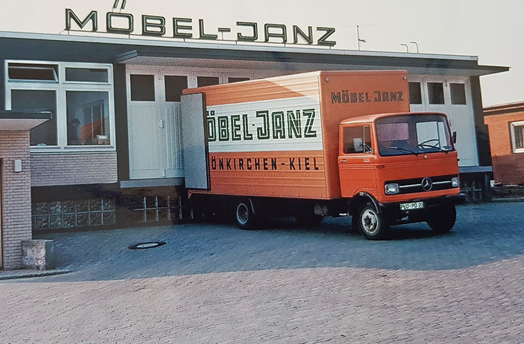 Altes Foto eines kleinen, orangenen Lkws mit dem Firmenlogo "MÖBEL-JANZ".