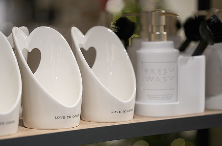 Weiße Keramik-Deko mit herzförmiger Aussparung, auf einem Regal präsentiert.