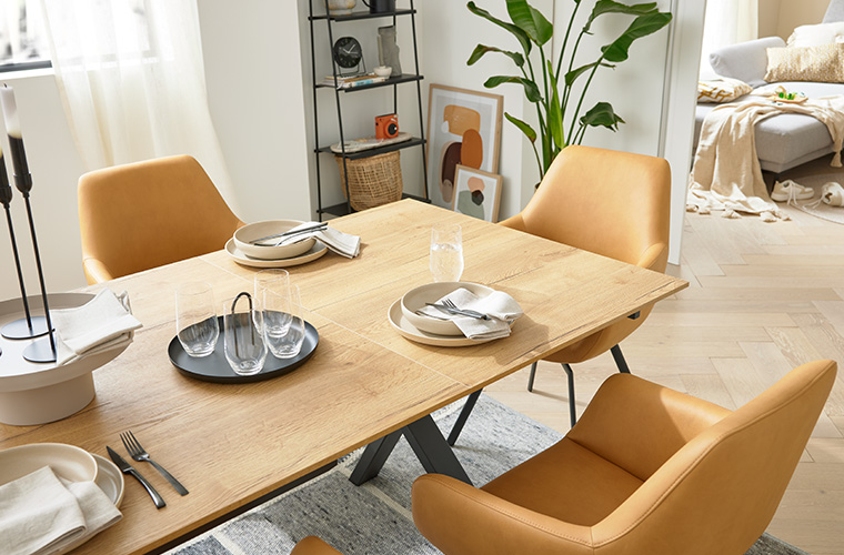 Modernes Esszimmer mit einem Holztisch umgeben von senfgelben Stühlen.