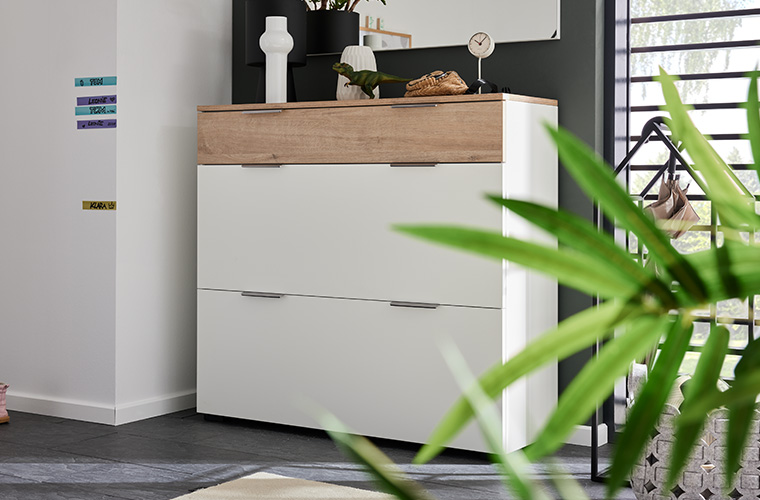 Breiter Garderobenschrank in weiß mit Holzdetails.