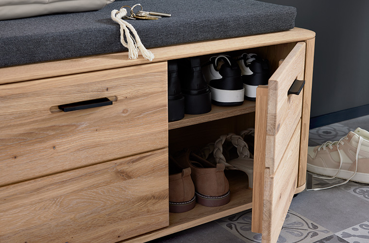 Offener Schuhschrank aus hellem Holz.