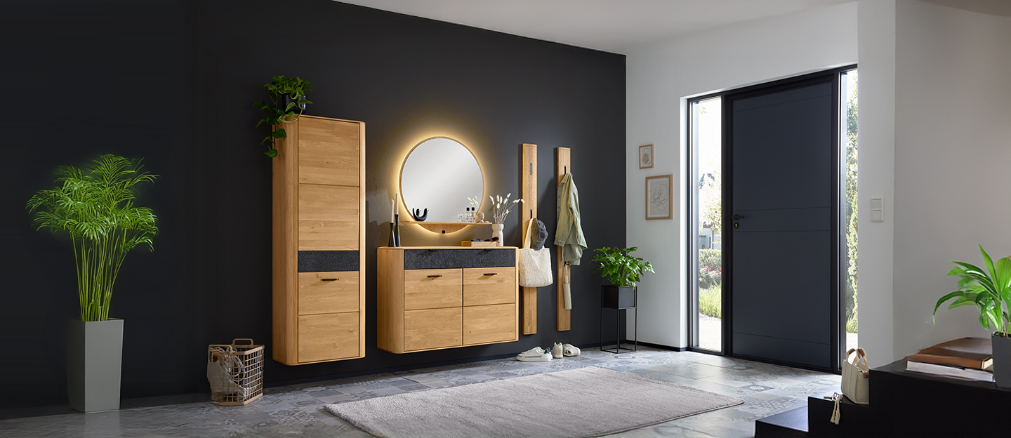 Modern eingerichteter Flur mit Holzgarderobe und rundem Spiegel.