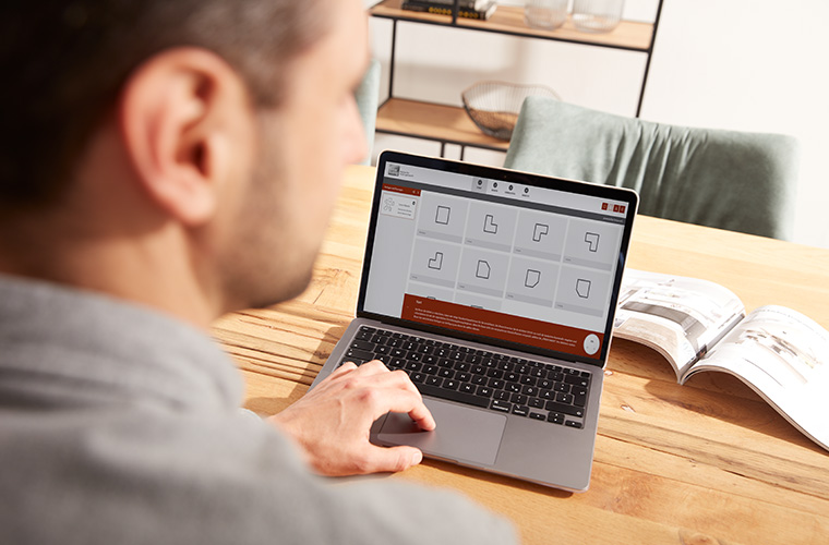 Ein Mann arbeitet konzentriert am Laptop.