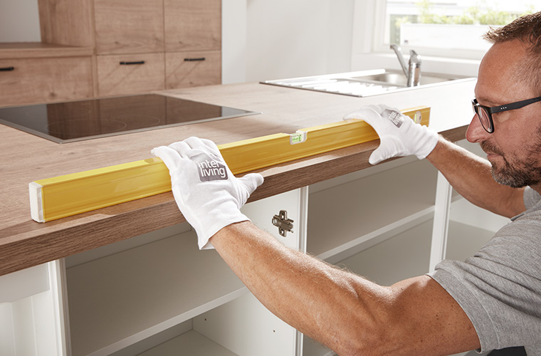 Ein Monteur nutzt eine Wasserwaage.