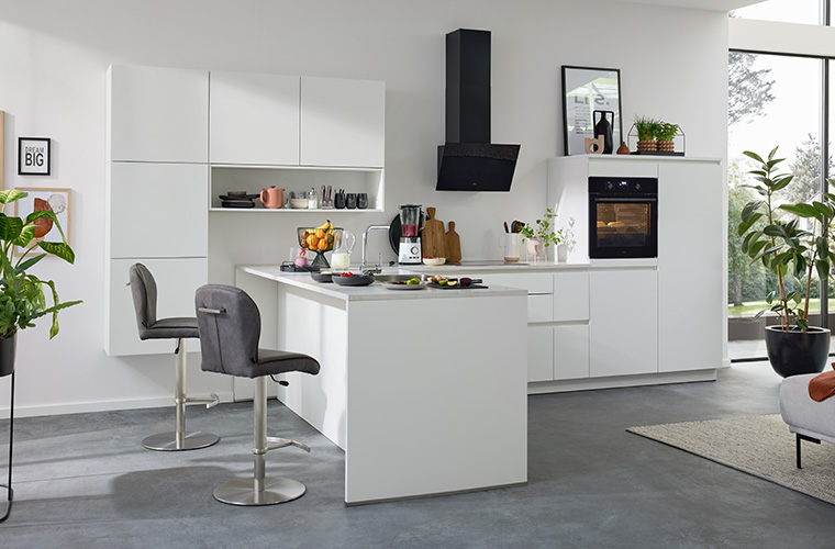 Helle, weiße Küche mit einer kleinen Kochinsel.