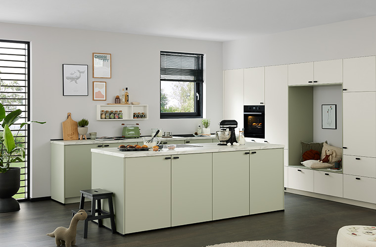 Helle Küche mit großer Kücheninsel in einem hellen Raum.