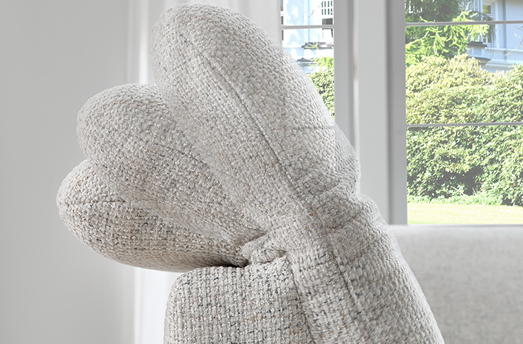 Nahaufnahme der grauen Kopfstütze eines Sofas.