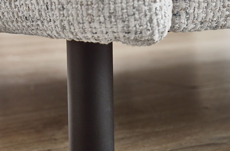 Detailaufnahme des schwarzen Möbelfußes eines Sofas.