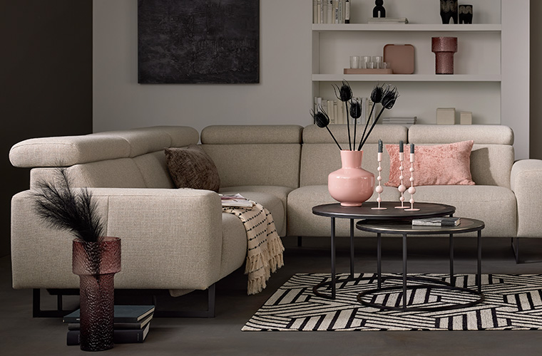 Modernes Wohnzimmer mit einem hellen Sofa und einem runden Couchtisch.