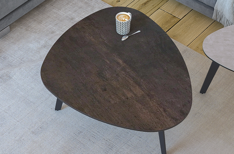 Couchtisch „Cailou CT 215 SD“ in organischer Form mit dunkler Tischplatte und Metallbeinen.