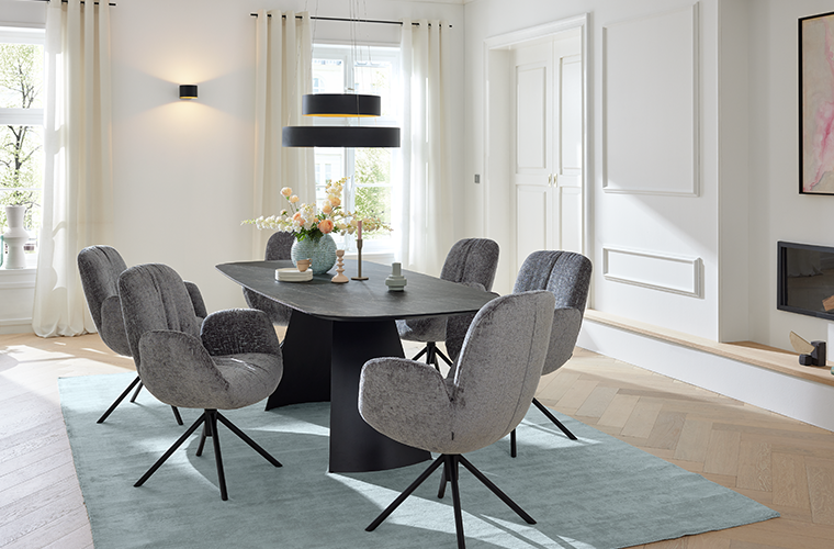 Musterring Essgruppe „MR Helvin“ mit schwarzem Tisch und grauen Polsterstühlen.