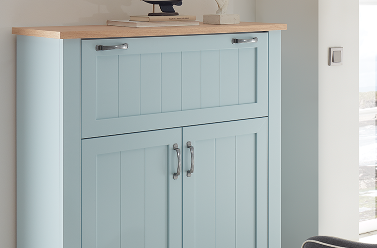 Kommode in Hellblau mit Holzplatte, Schublade und Türen mit Metallgriffen.