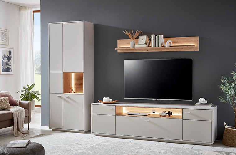 Wohnwand „Nordhausen“ in modernem Grau mit LED-beleuchteten Elementen und Holzdetails.