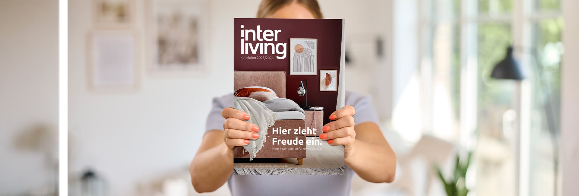 Frau hält Interliving Magazin in die Kamera.