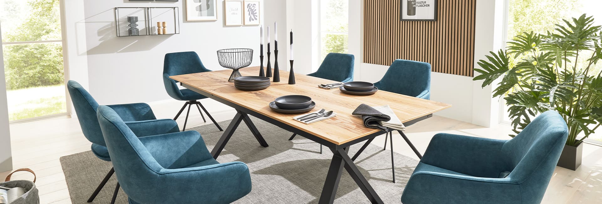 Interliving Essbereich mit einem Tisch in Holzoptik und dunkelgrauen Stühlen.