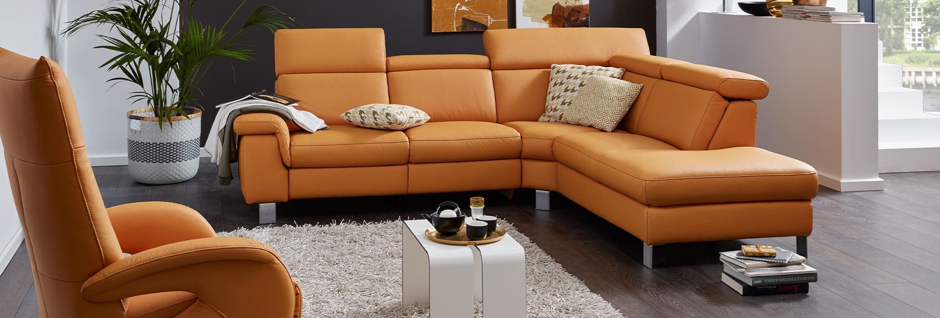 Interliving Eckkombination in dunkelgraue und mit bunten Kissen.