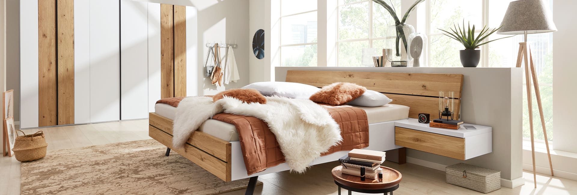 Helles Schlafzimmer mit Holzdetails, großem Bett und minimalistischem Nachttisch.