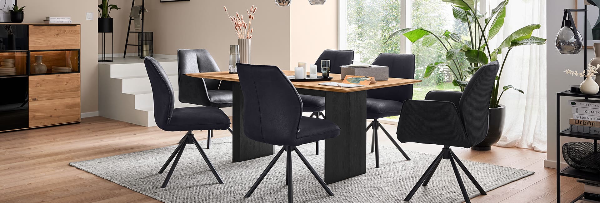 Dunkler Esstisch mit sechs schwarzen Stühlen in einem Esszimmer.