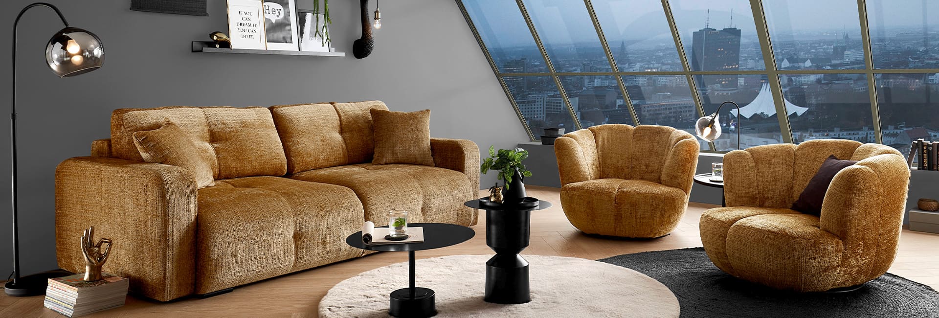 Senfgelbe Sitzgruppe bestehend aus zwei Sesseln und einem Sofa.