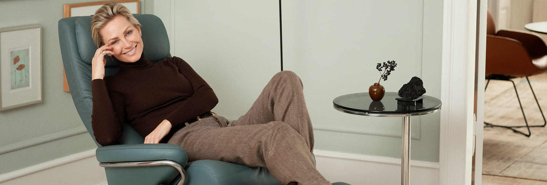 Frau entspannt im Stressless® Sessel in einem modernen Wohnzimmer.